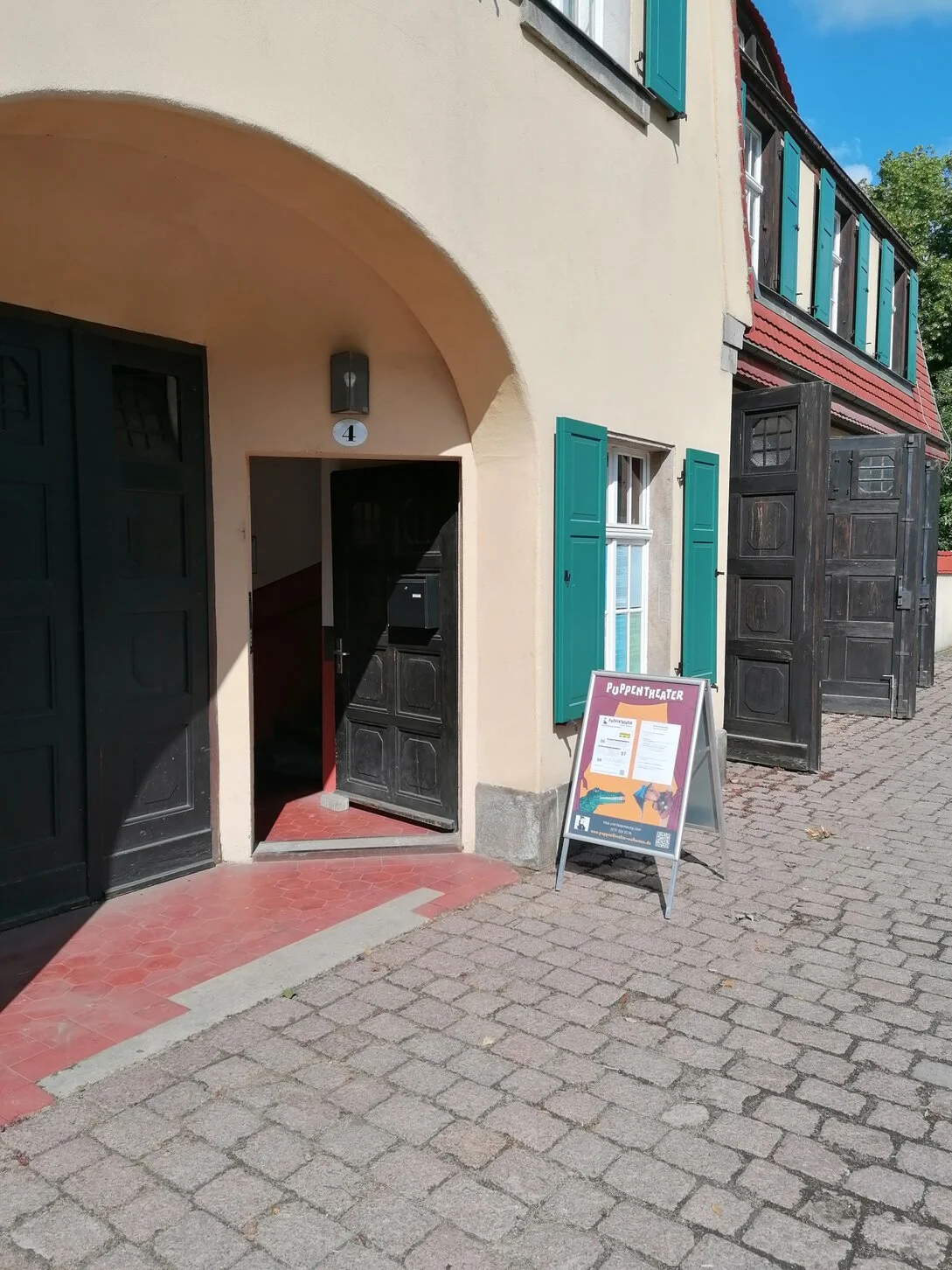 Der Eingang zum Puppentheater mit einem Aufsteller davor.