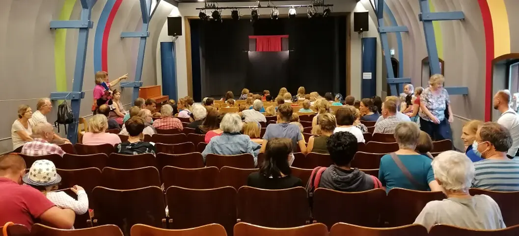 Familien vor eine Puppenbühne in einem Theatersaal